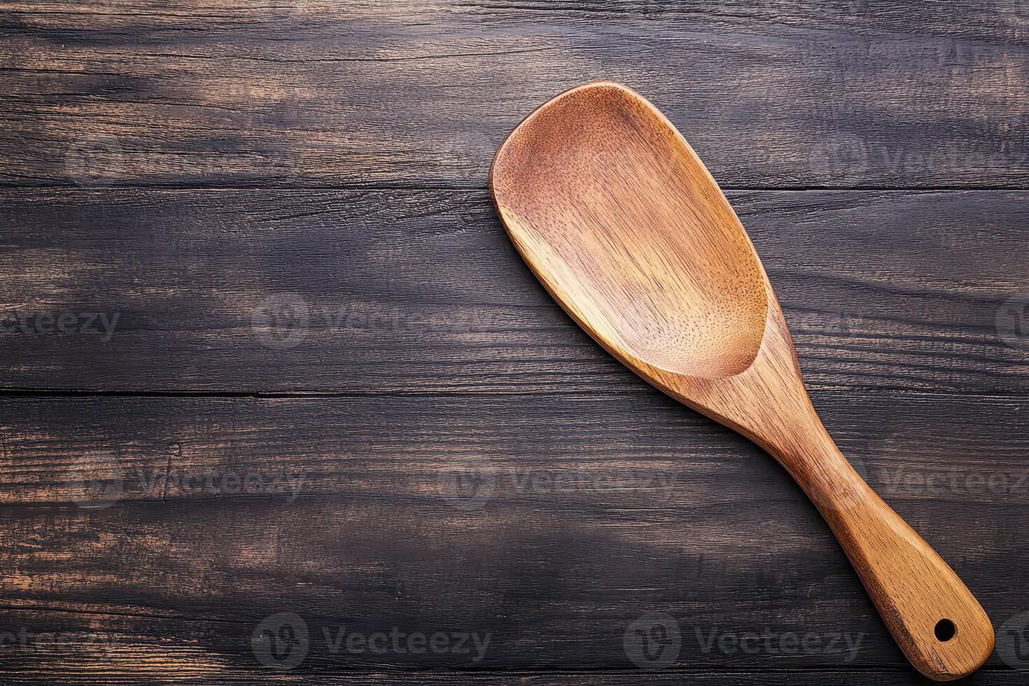 Wooden cooking utensil resting on wooden surface photo