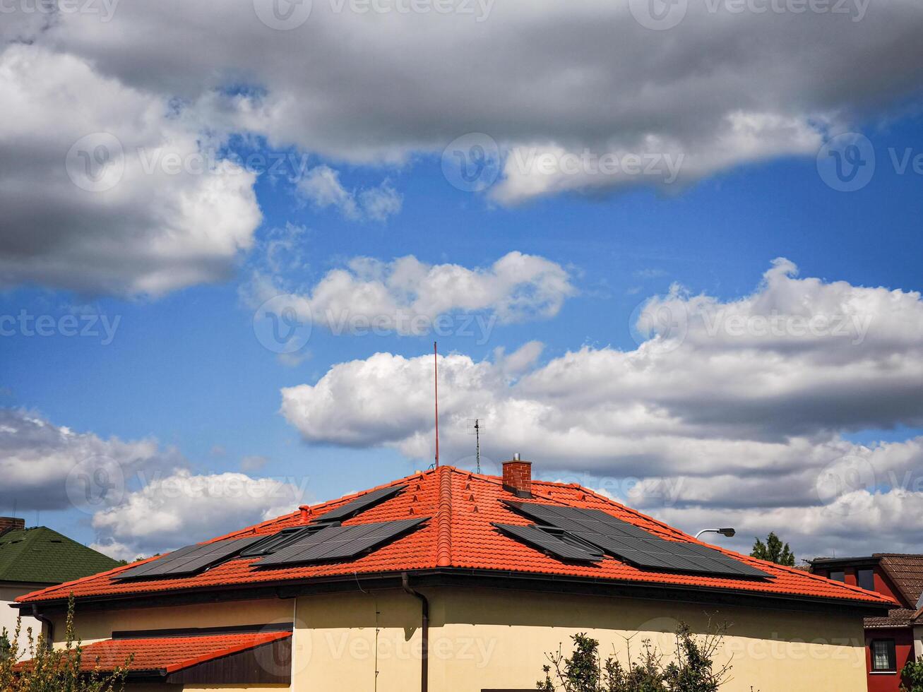Solar panels on a modern rooftop under a dramatic sky filled with clouds showcasing renewable energy solutions and sustainable living concept photo