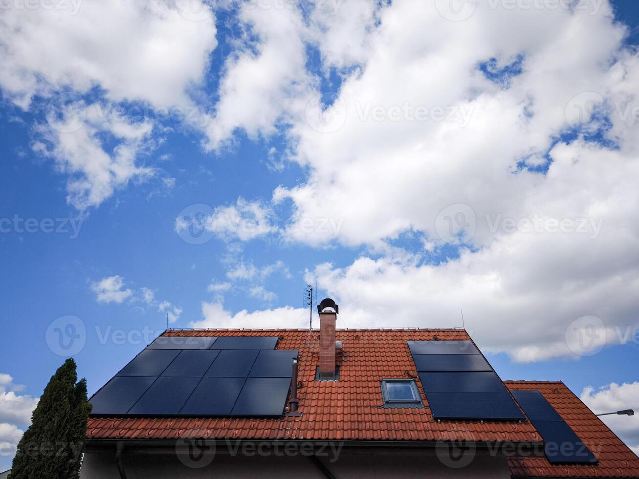 Solar panels installed on a modern rooftop under a bright blue sky with fluffy clouds showcasing renewable energy and sustainability concept photo