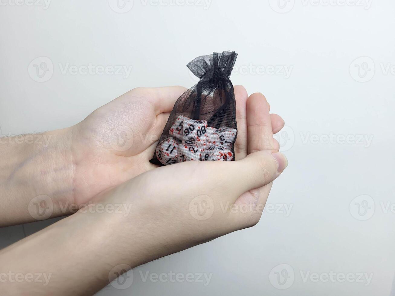 His hands are holding a black transparent bag with cubes. Table games. Holiday leisure. photo