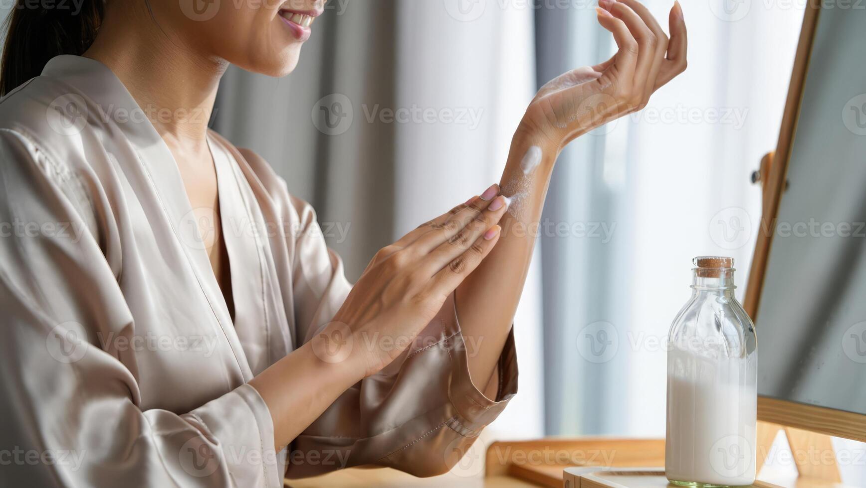 Applying moisturizer to arm in a well lit room during a self care routine while preparing for the day ahead photo