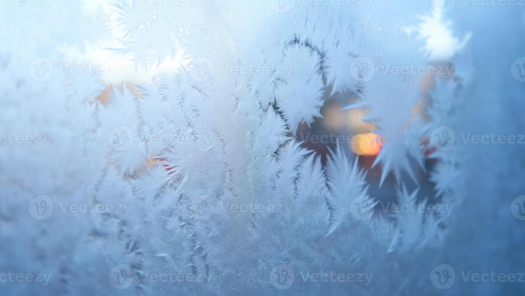 Frost patterns adorn a window as winter evenings approach, capturing the beauty of cold temperatures and the artistry of nature in urban settings photo
