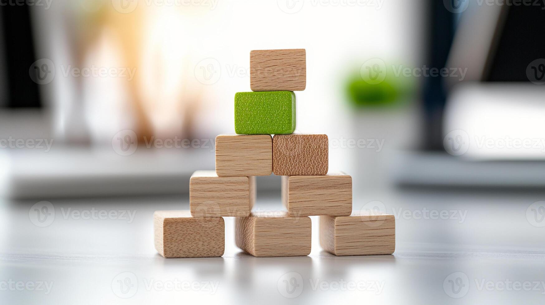Colorful wooden blocks arranged in a pyramid on a desk with blurred office background photo