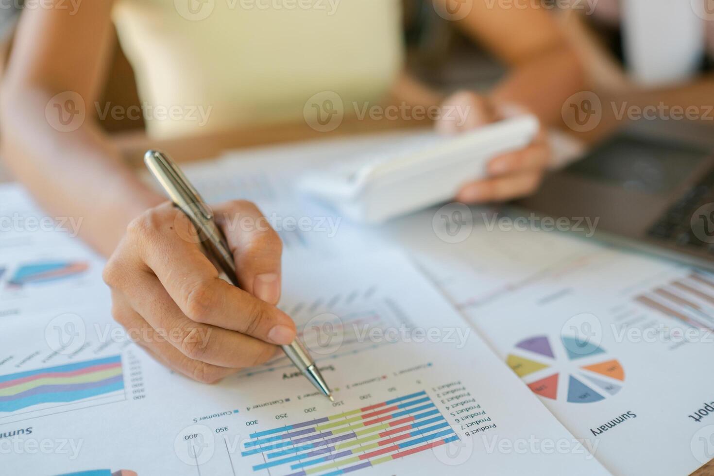 Close-up of a person reviewing financial data with charts, graphs, and a calculator, highlighting business analysis and planning. photo