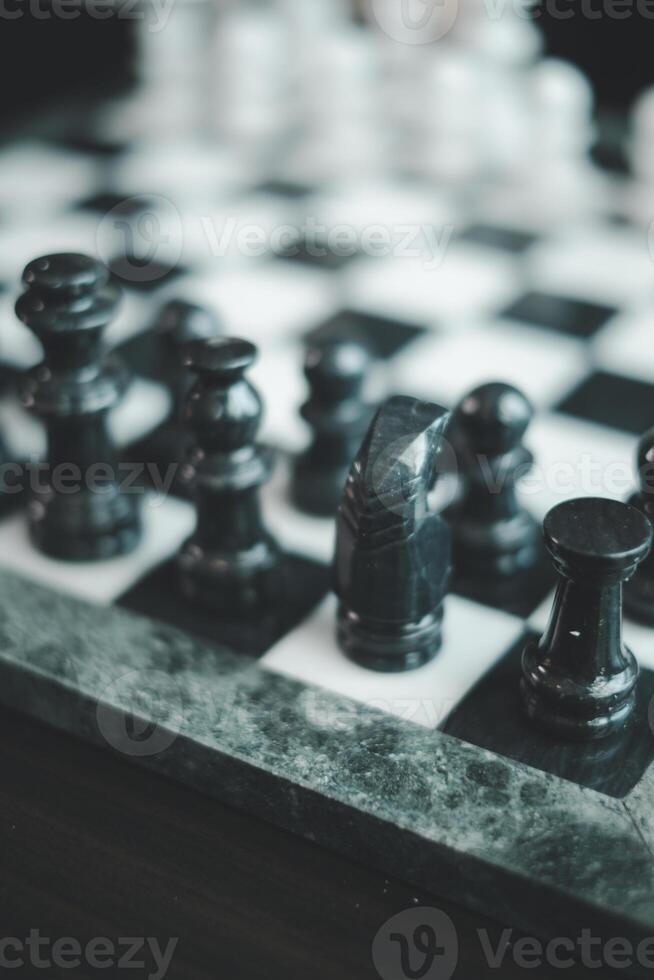 Artistic close-up of black chess pieces on a marble board, highlighting strategic gameplay and elegant design. photo