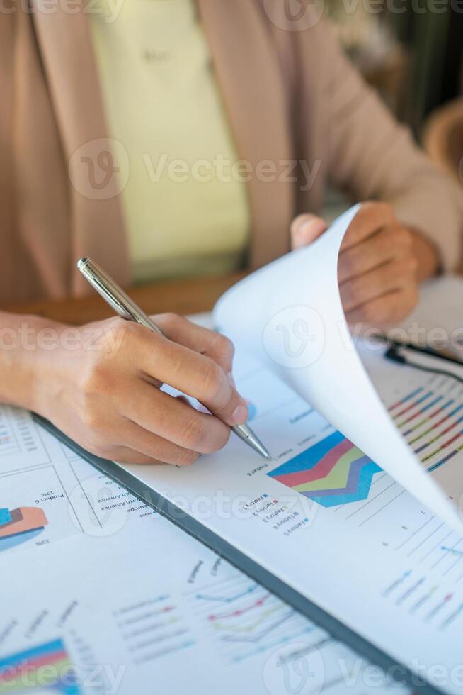 Close-up of a person reviewing financial charts and graphs, data analysis and business strategy. photo