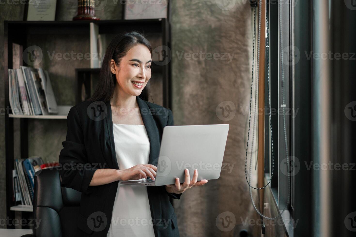 Confident businesswoman using laptop in a stylish office setting, showcasing modern work environment and technology. photo