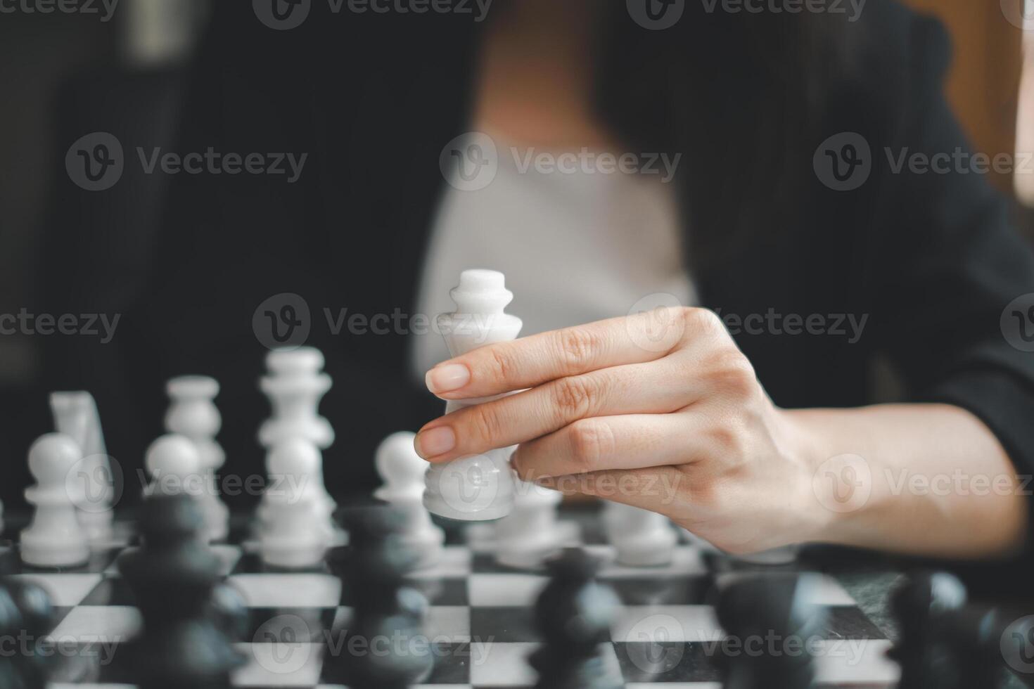 Close-up of a hand holding a chess piece during a strategic game, emphasizing focus and strategy. photo