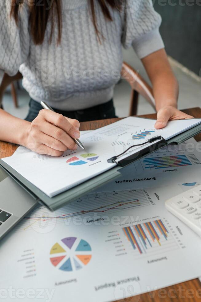 Professional woman reviewing financial reports with charts and graphs, highlighting business analysis and strategy. photo