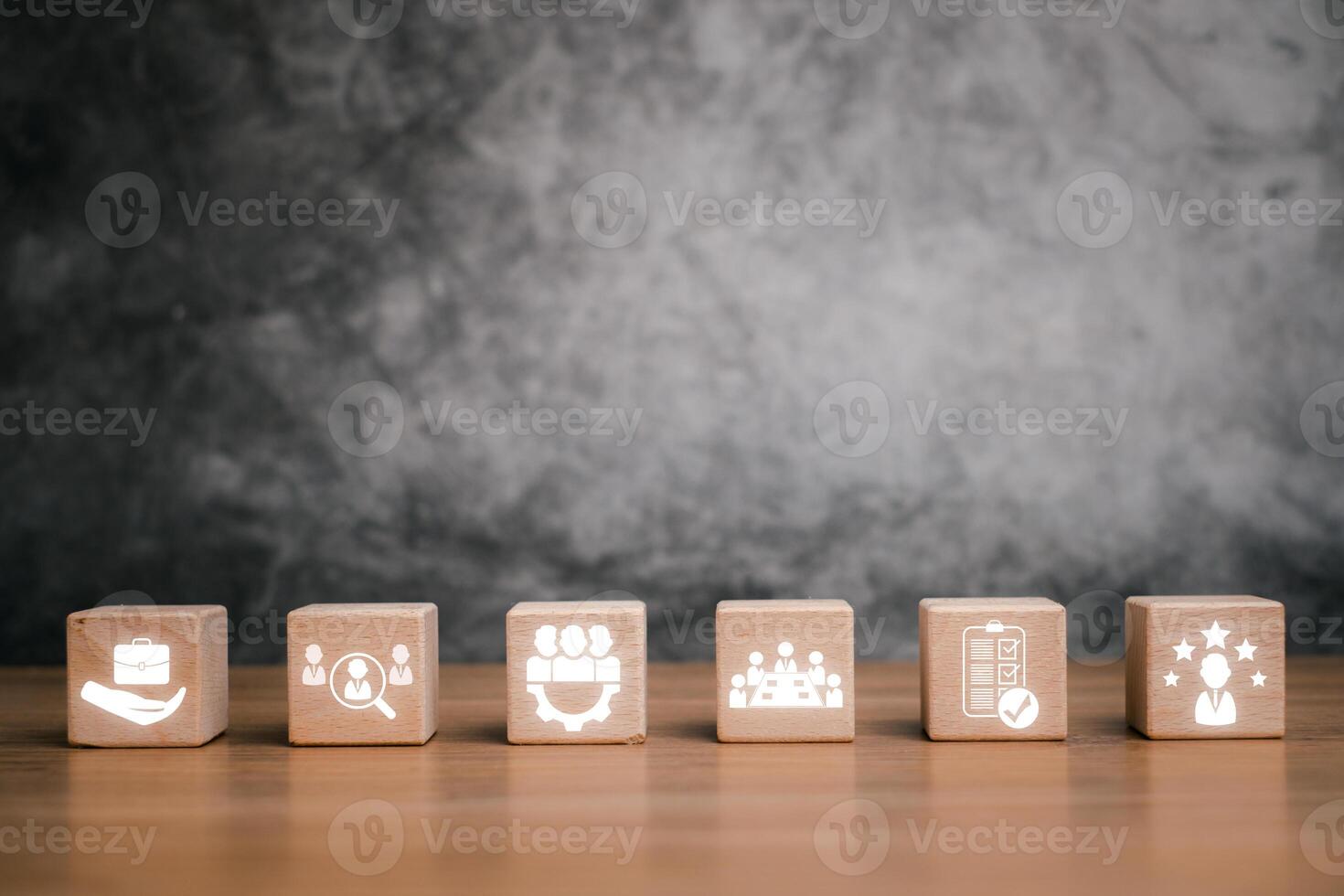 Wooden blocks symbolize assessment center concepts like teamwork, evaluation, and business strategy on a textured background. photo