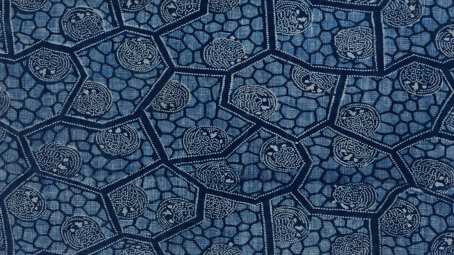 A blue and white patterned fabric with a design of skulls photo