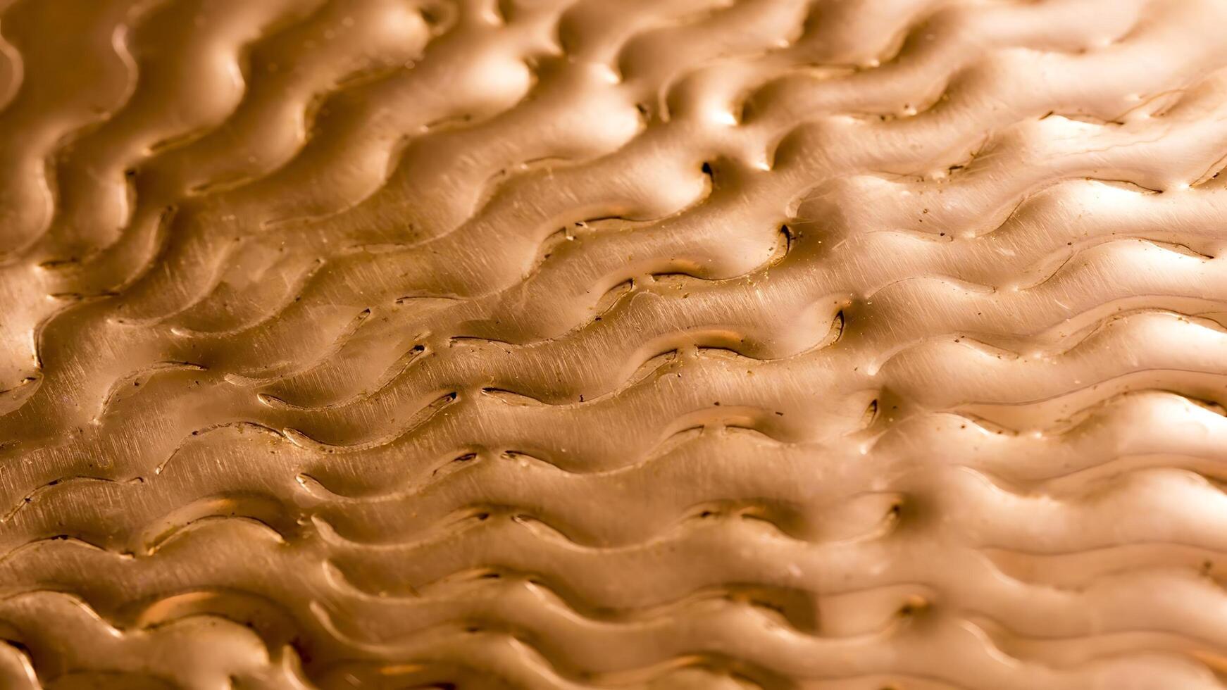 A close up of a gold surface with wavy lines photo