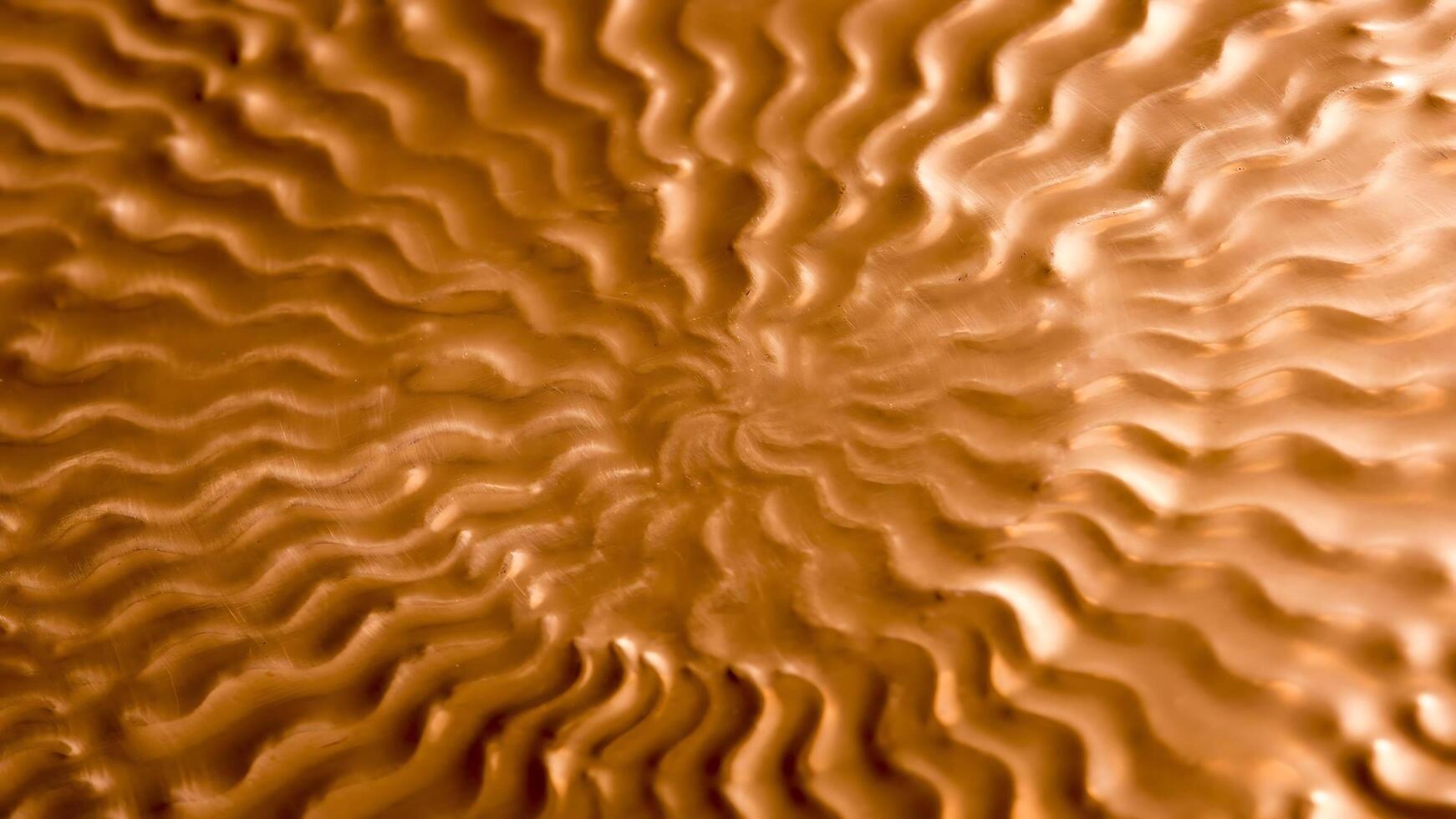 A close up of a copper surface with waves photo