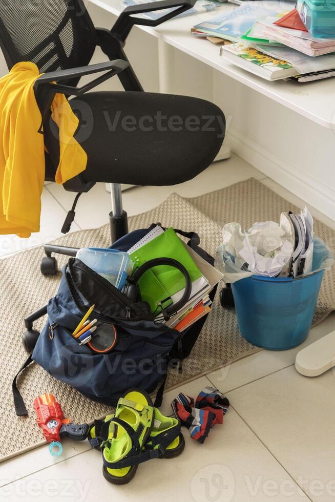 cluttered workspace with school books, backpack, and scattered supplies. Symbolizing teenage habits. photo