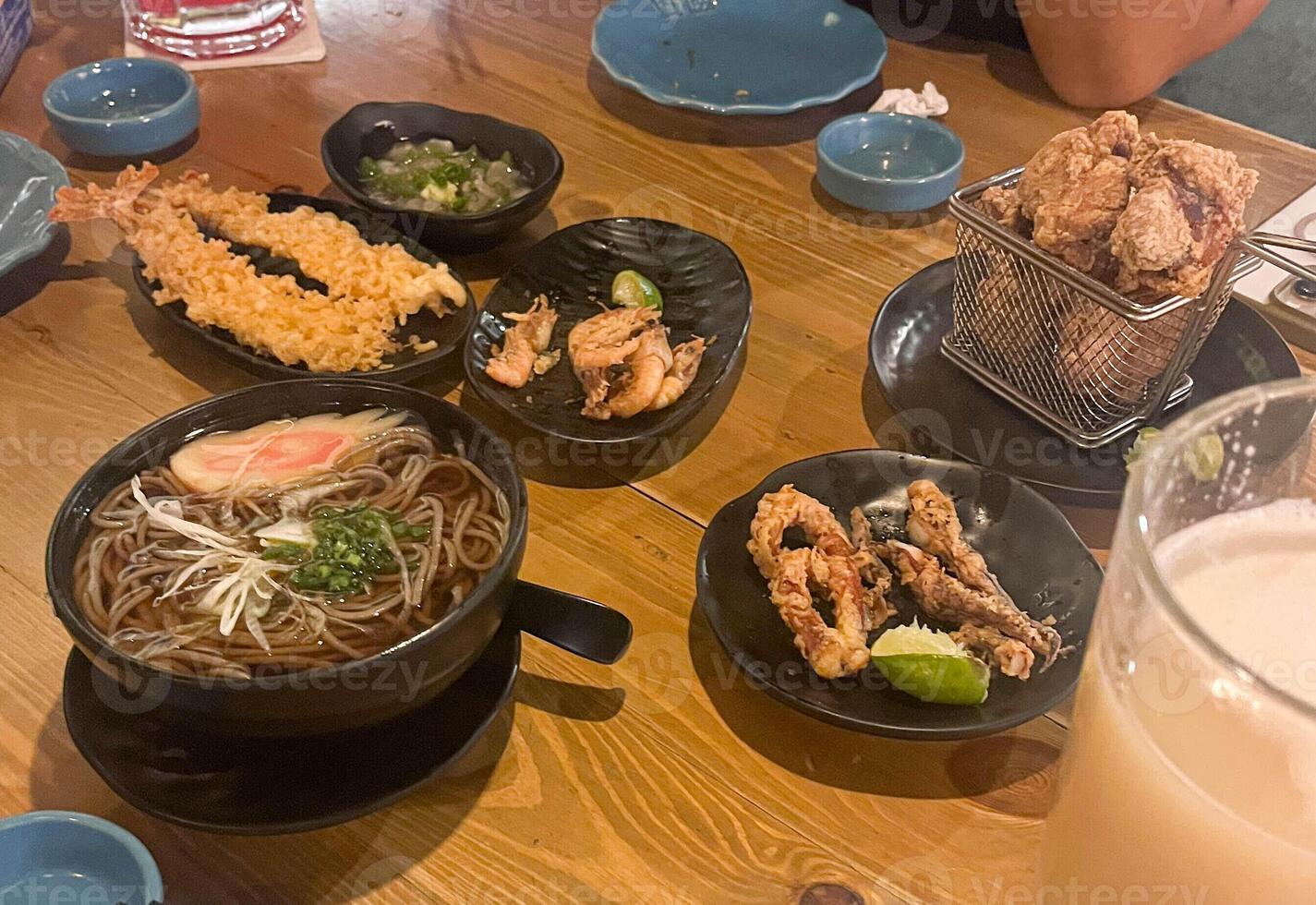 Japanese dinner at an izakaya with fried food. Ramen Teppura, Fried Chicken and Pickled Wasabi Squid photo