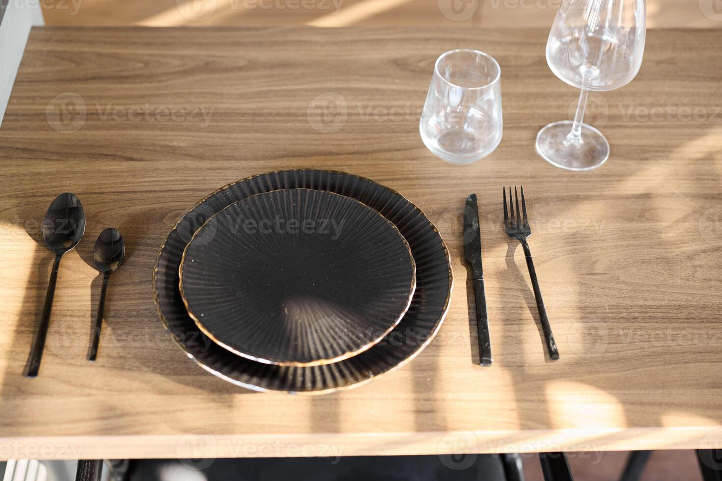 An elegantly designed black dining setup featuring exquisite glassware and fine cutlery photo