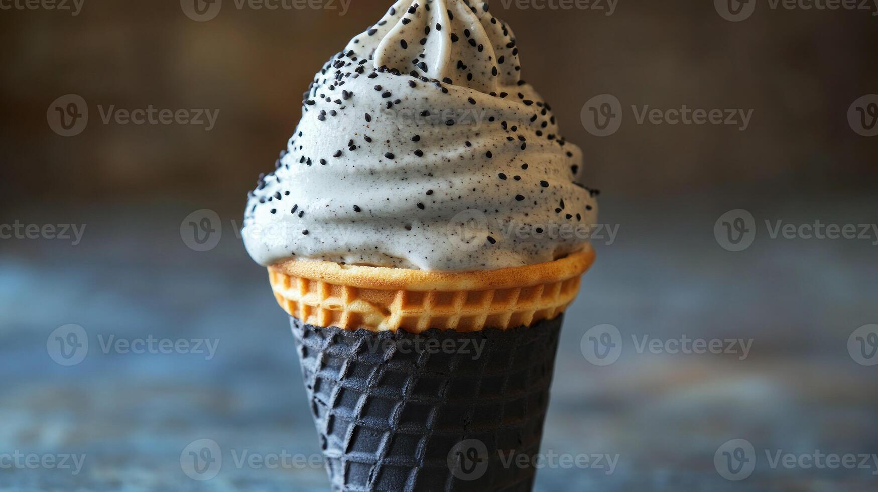 Black waffle cone with light gray ice cream topped with black seeds photo
