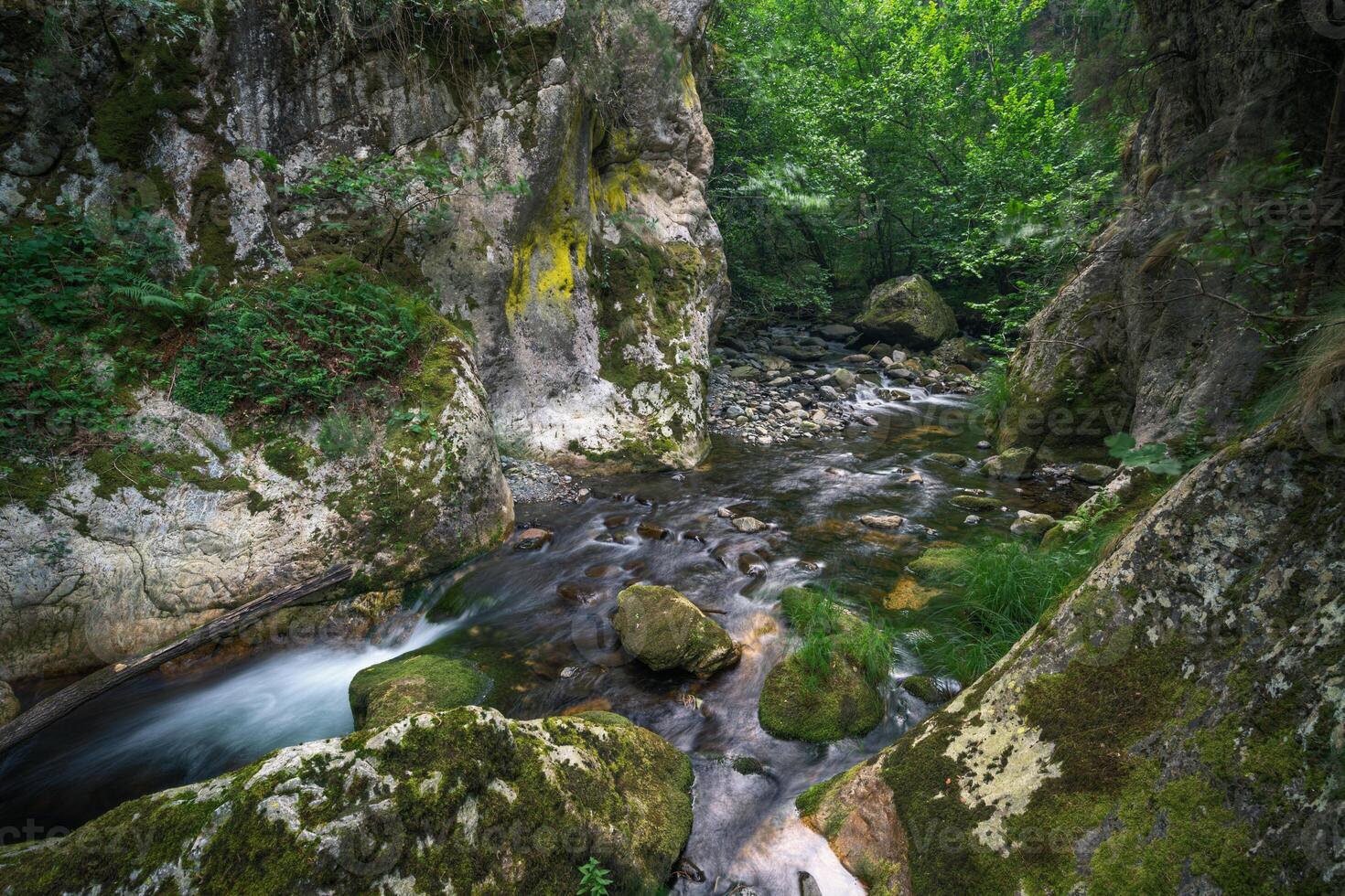 A river patiently carves its way through the hard granite rock photo