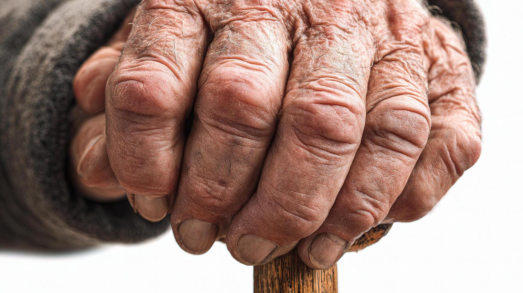 An elderly person's hands holding a wooden stick photo