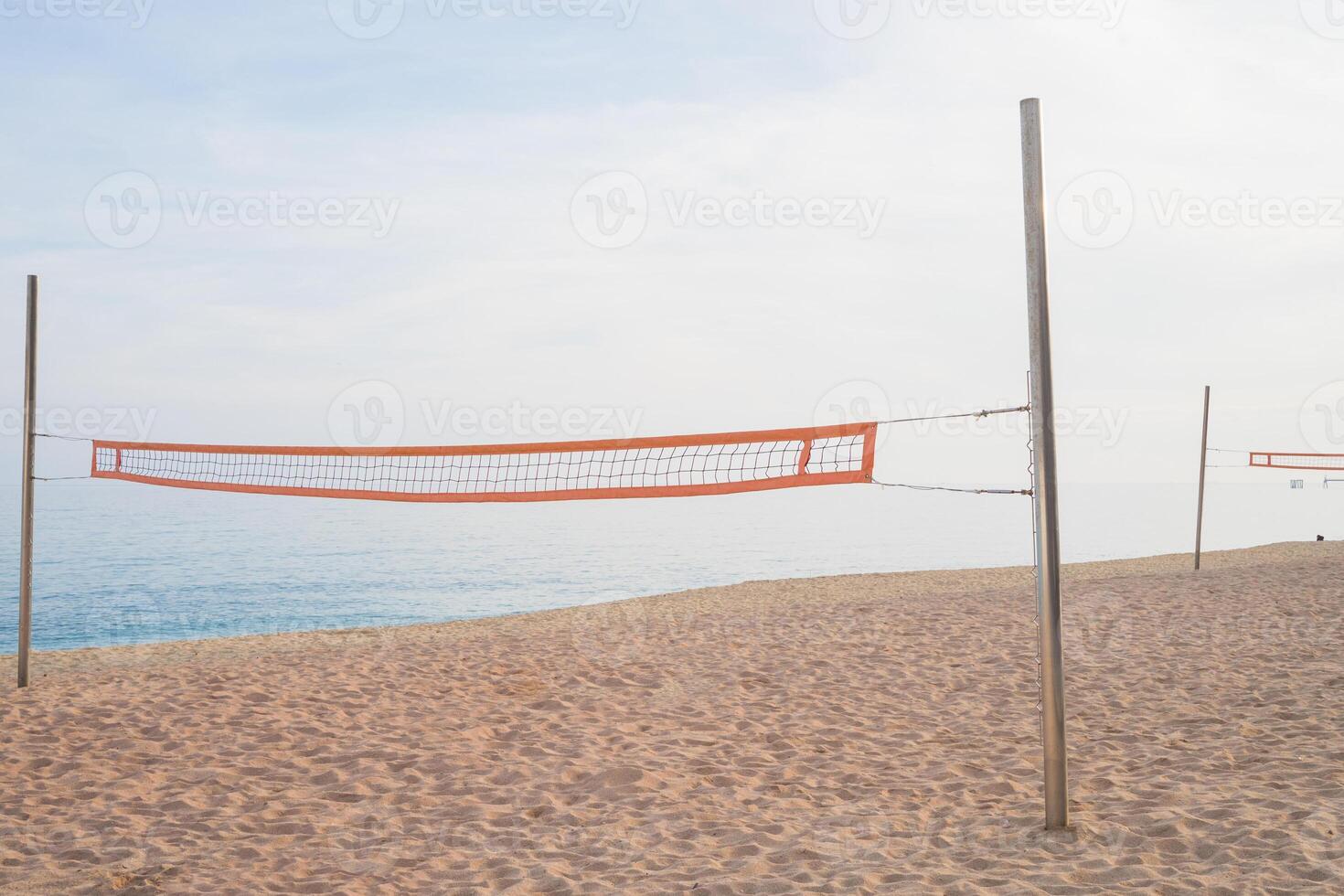 Empty beach volleyball court on a tranquil sandy shore photo