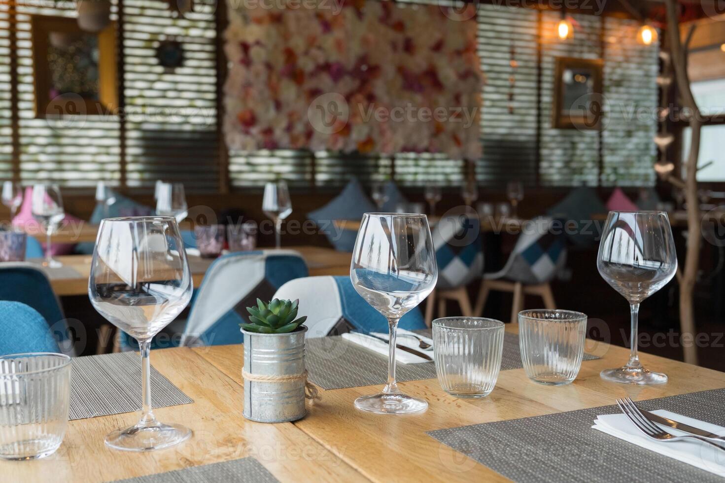 Elegant restaurant interior with empty tables and wine glasses photo