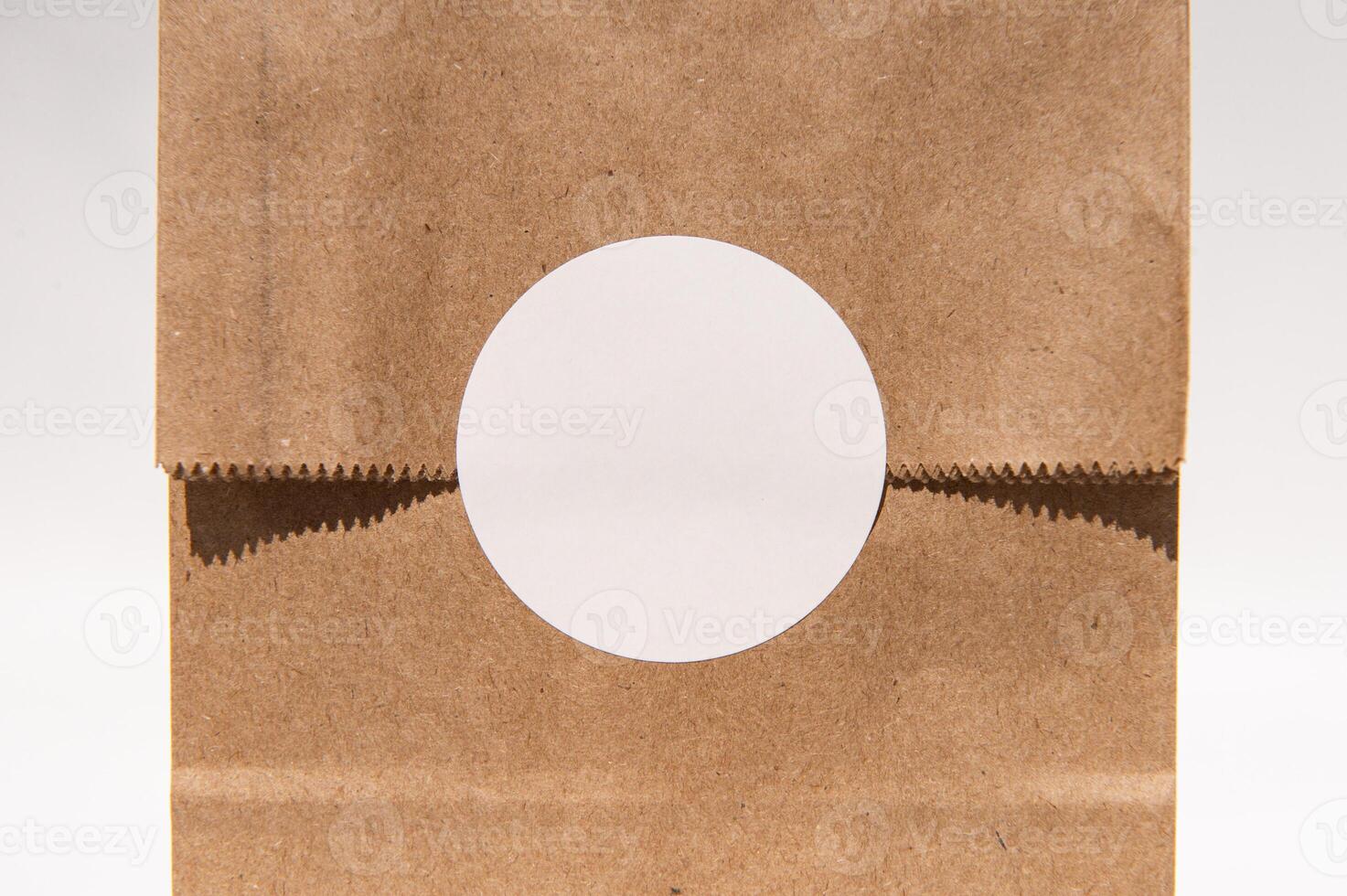 Blank circular sticker on brown paper bag for custom design photo