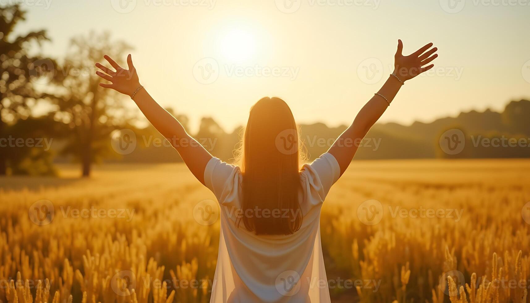 A woman with her arms up in the air in a wheat field photo