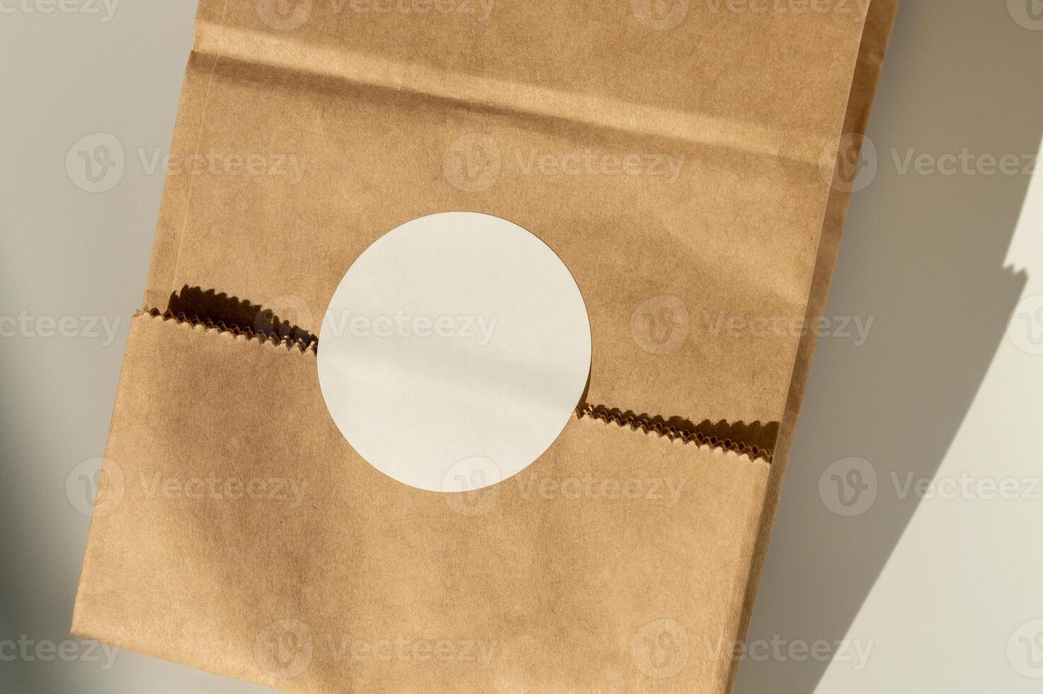 Brown paper bag with circular cutout on plain background photo