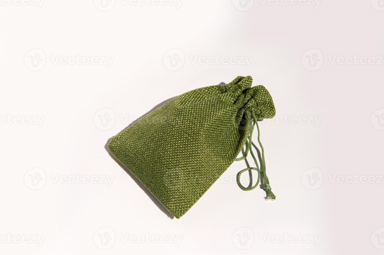 Green fabric drawstring bag on white background elegant textured storage pouch photo