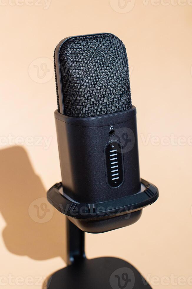 Black studio microphone with isolation shield on beige background photo