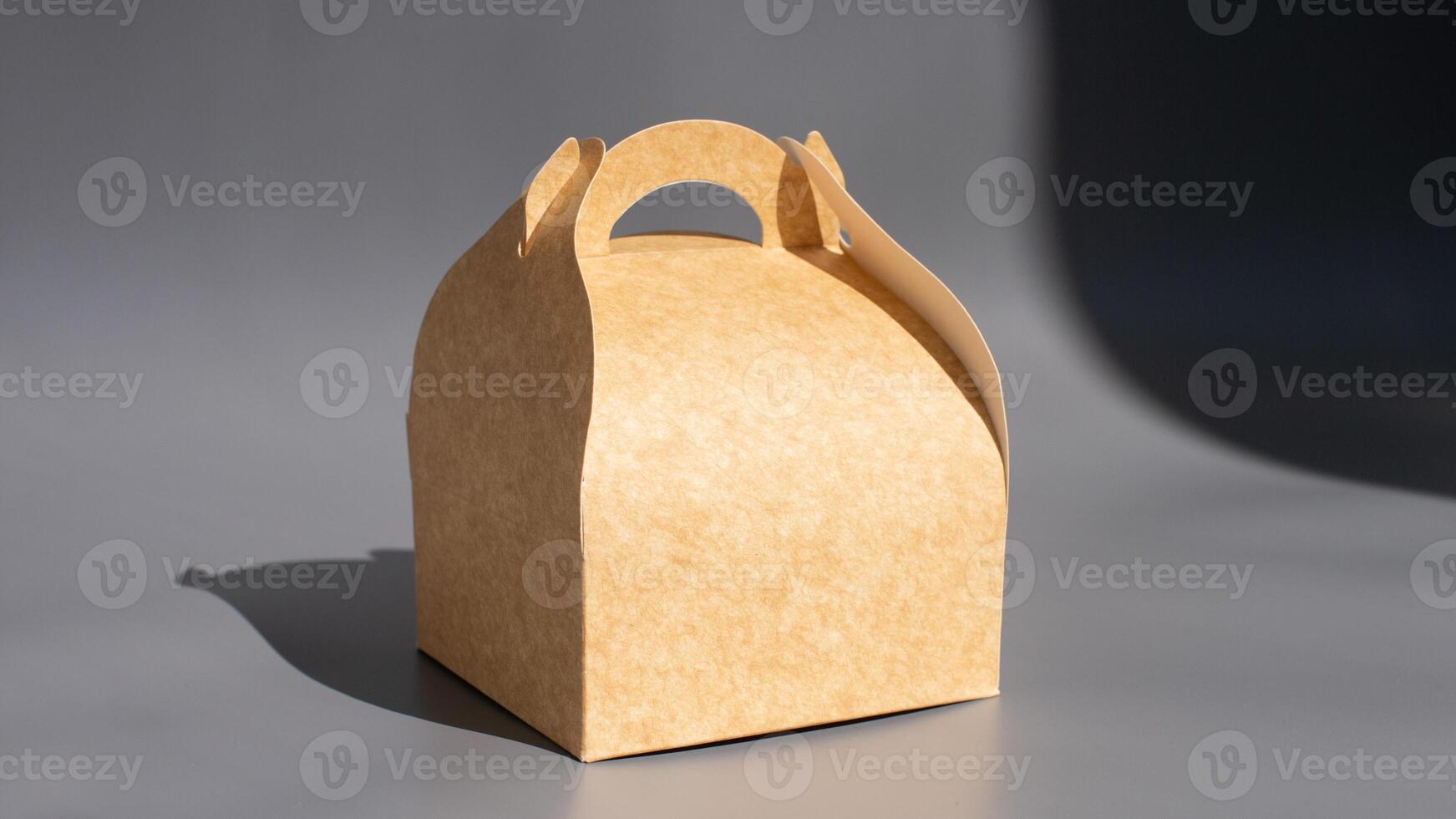 Eco-friendly brown kraft paper box on gray background with shadow photo