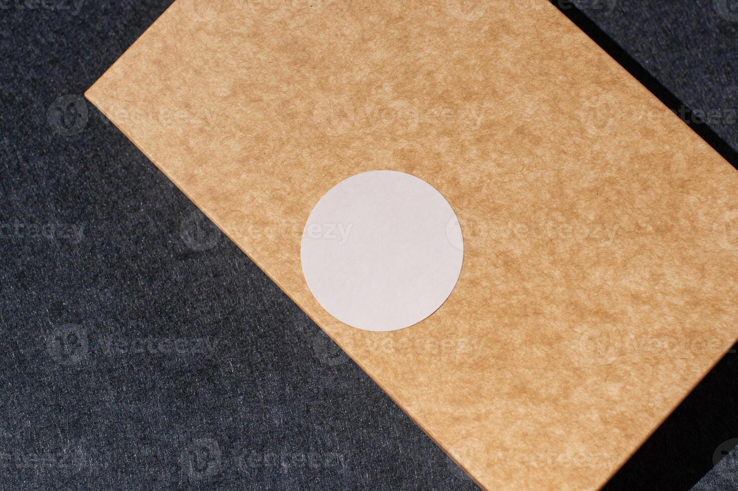 Close-up of brown cardboard box with circle sticker on dark background photo