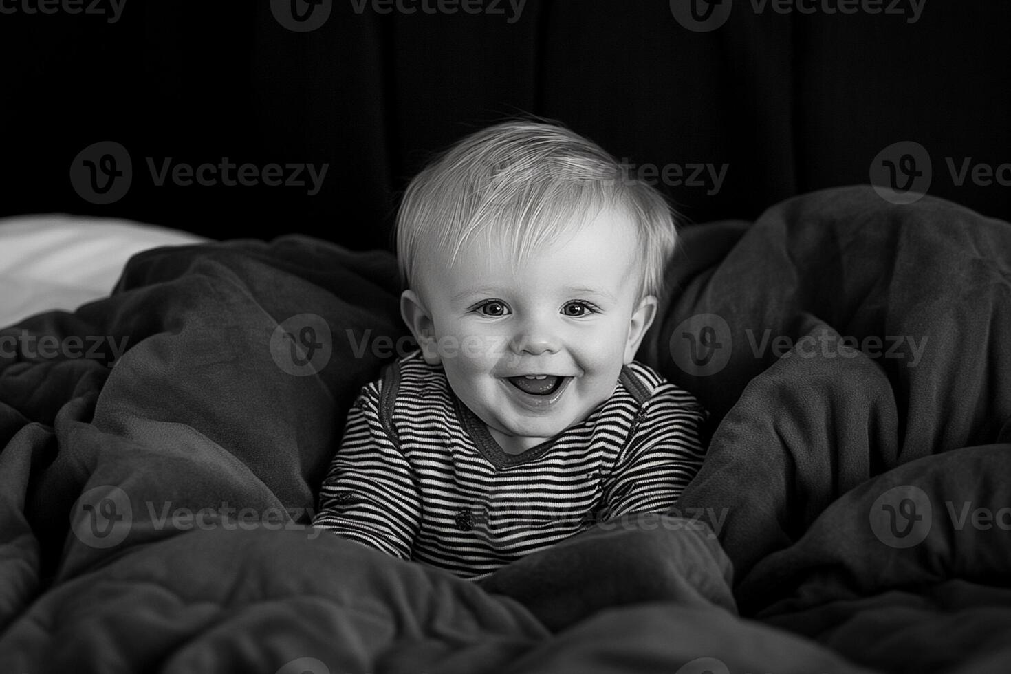 A baby smiling in a black and white photo