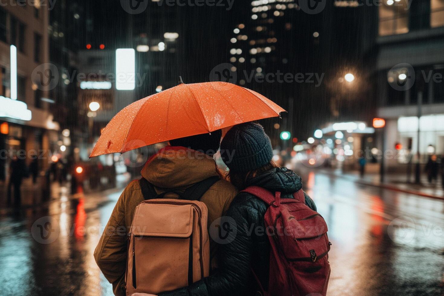 Two people with backpacks and umbrellas walking in the rain photo