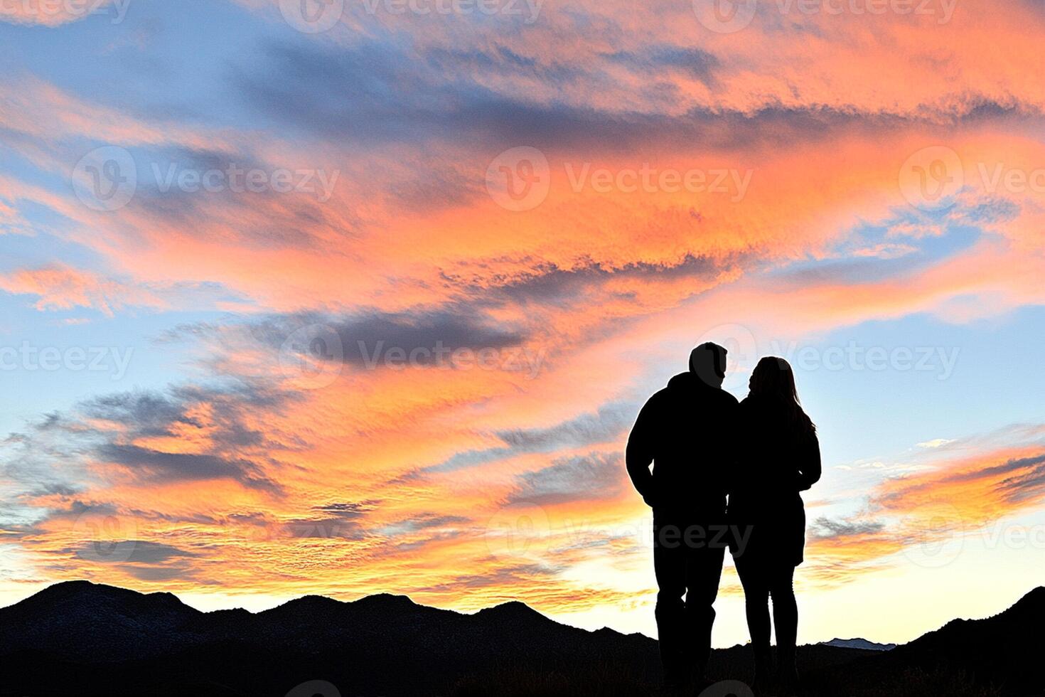 A couple standing in front of a sunset photo