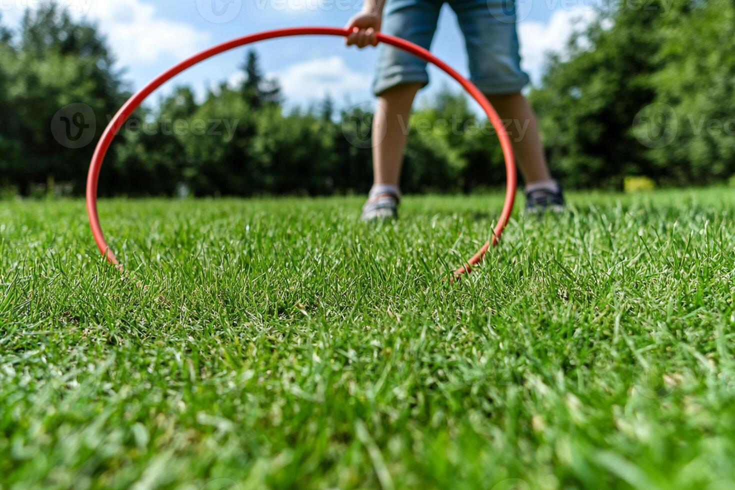 A child playing with a hula hoop in the grass photo