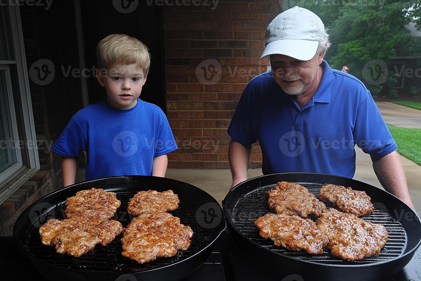A man and a boy cooking burgers on a grill photo