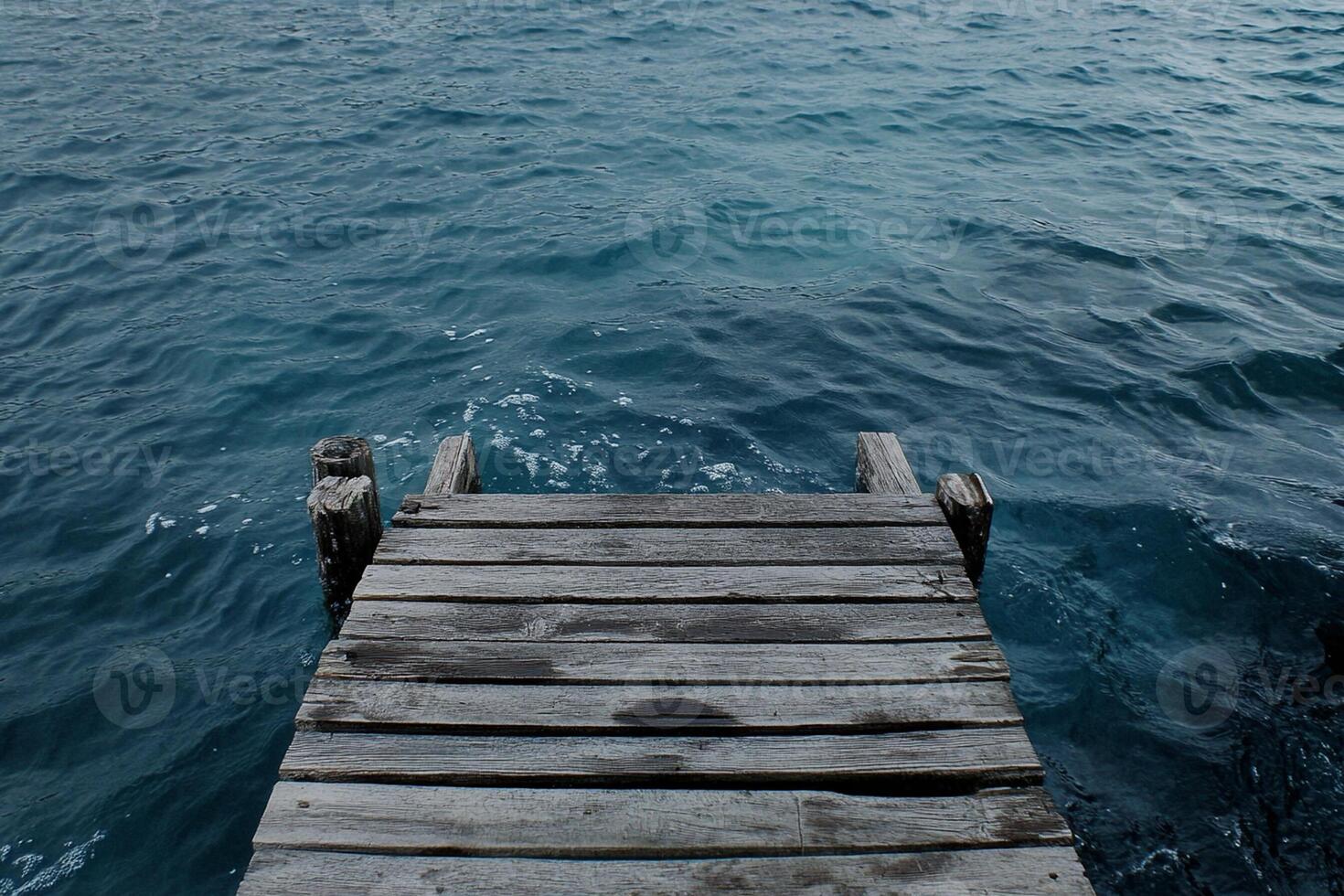 A wooden dock that is over the water photo