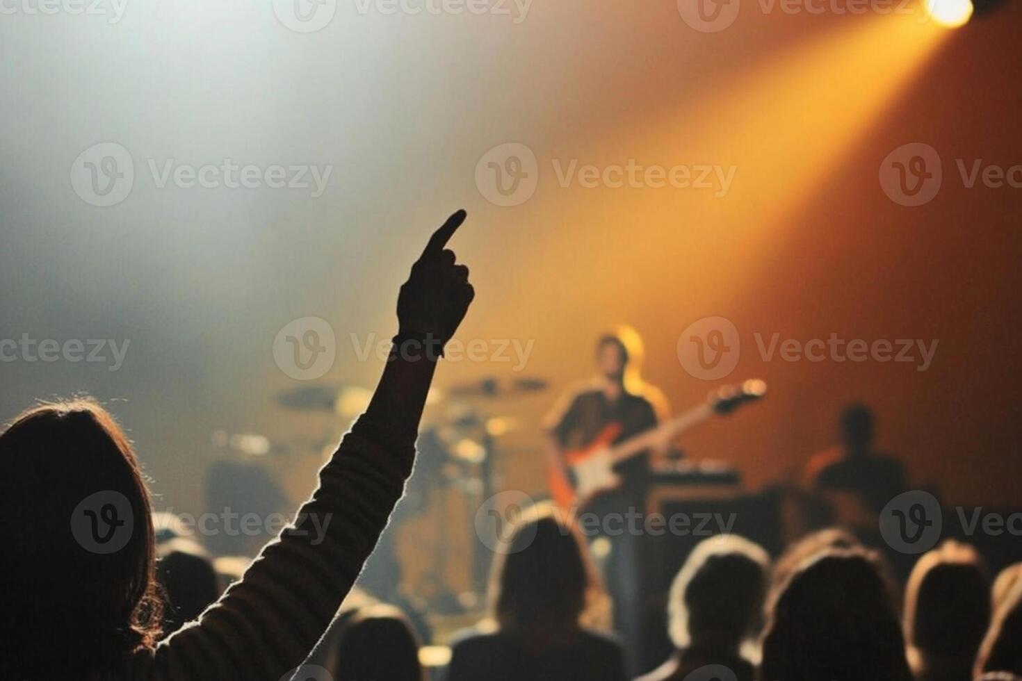 A person raising their hands in front of a crowd photo