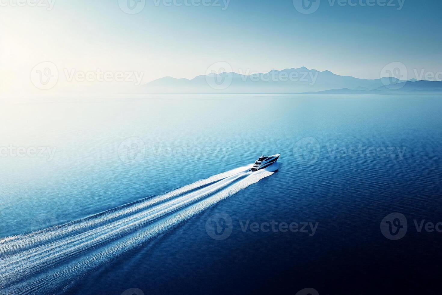 A boat traveling across the ocean with mountains in the background photo