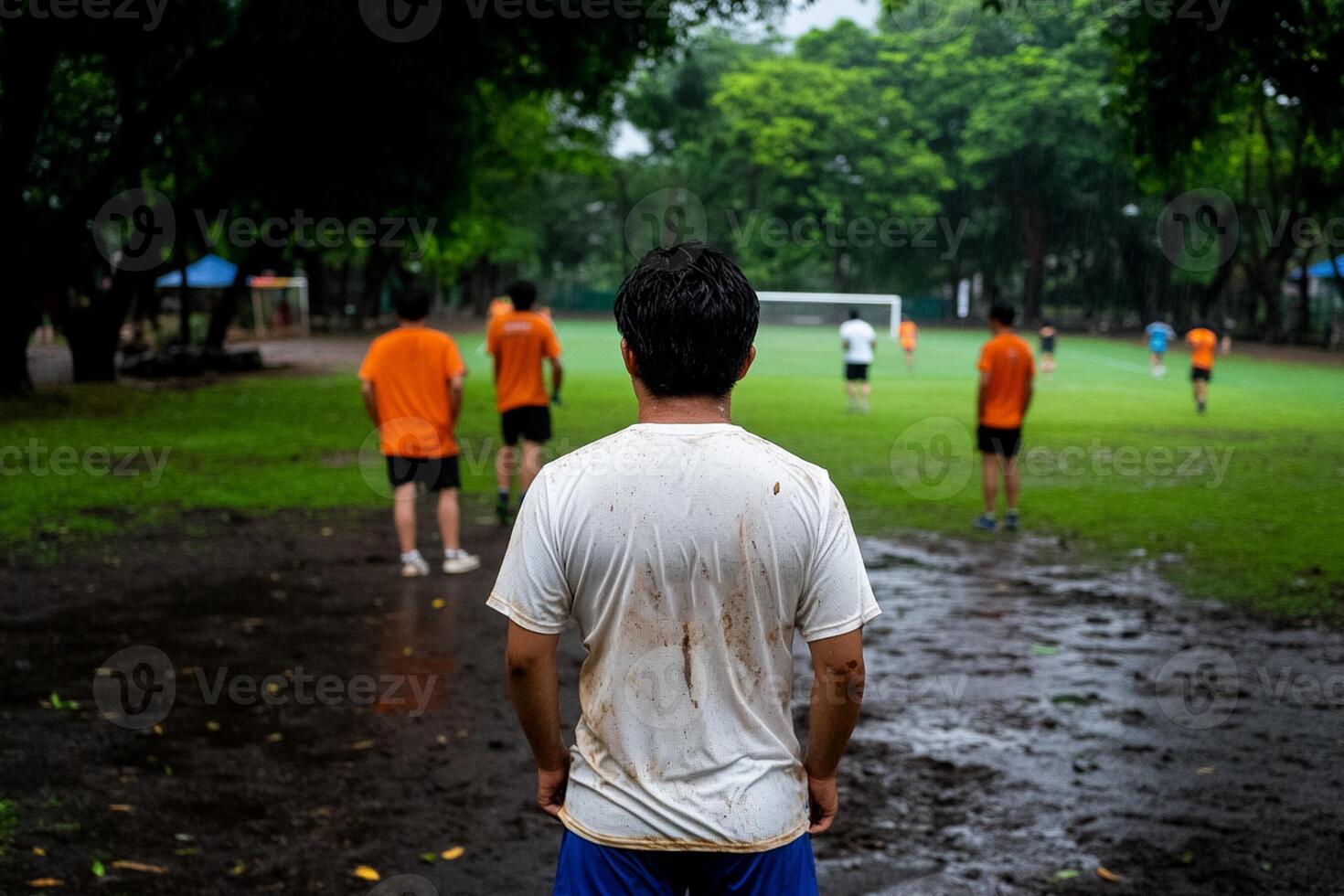 A man standing in the mud on a soccer field photo