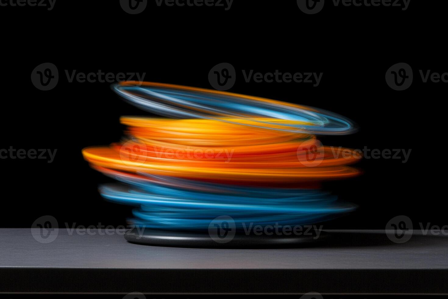 A stack of colorful rings on a black surface photo