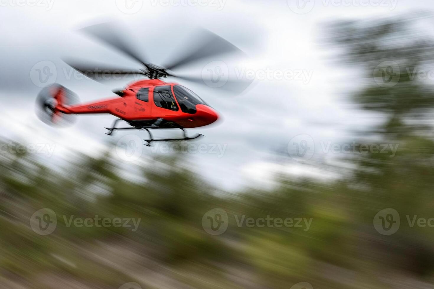A red helicopter flying through the air photo
