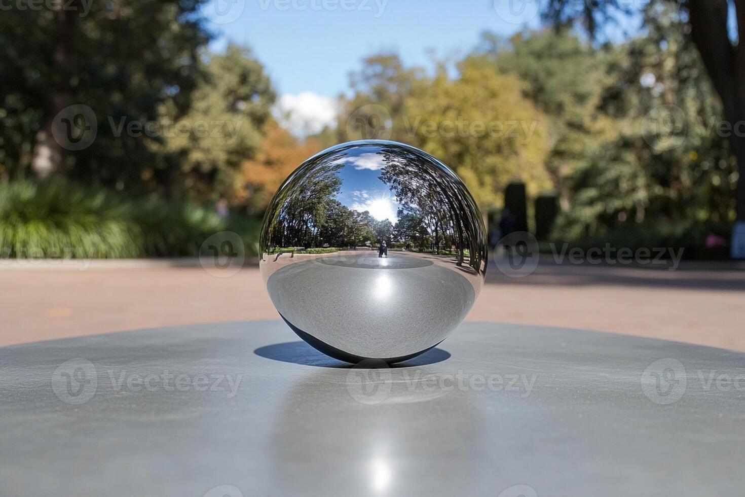 A shiny ball sitting on a table in a park photo