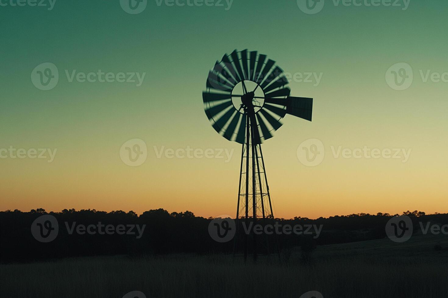 A windmill stands in the middle of a field photo