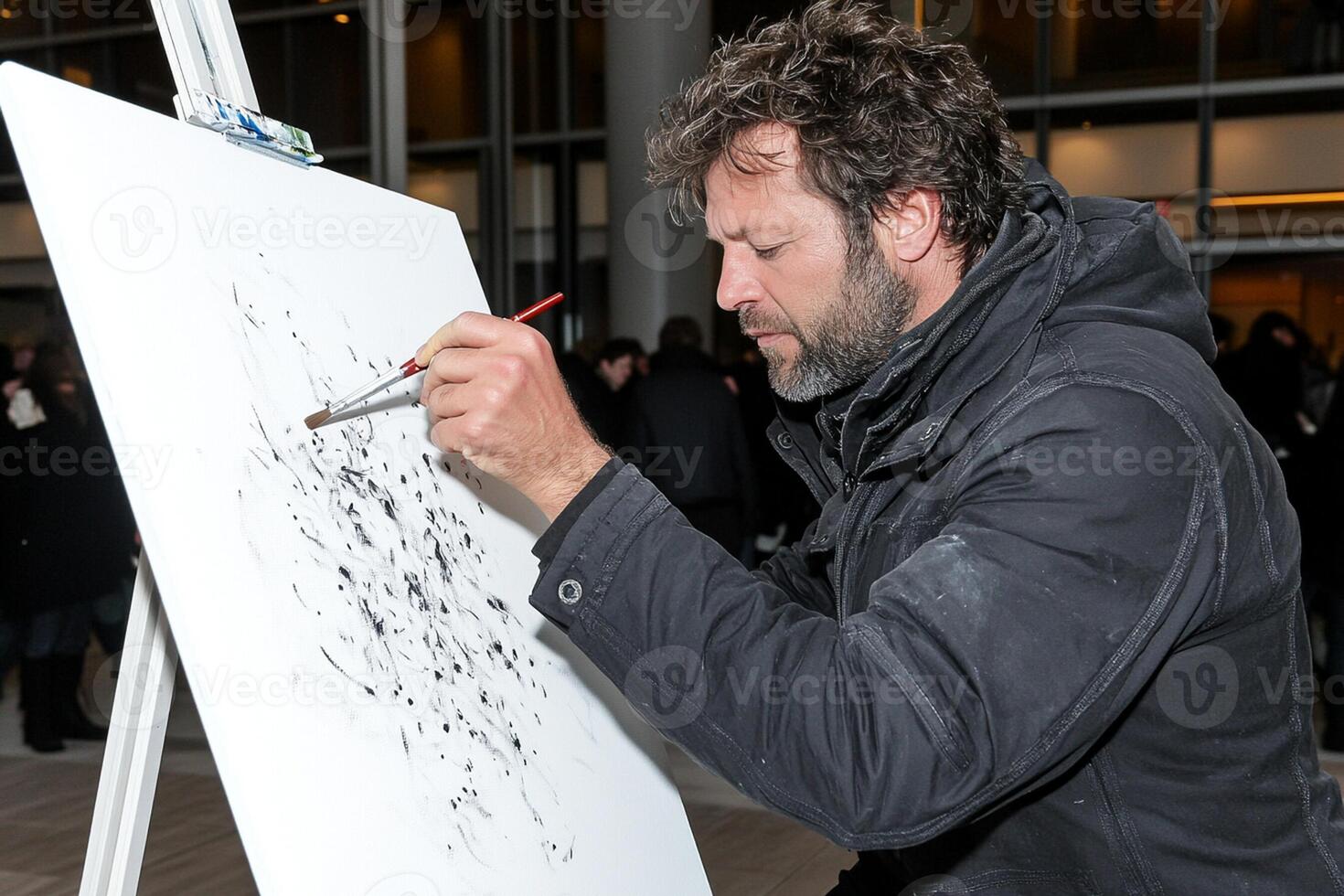 A man is painting on an easel with a brush photo
