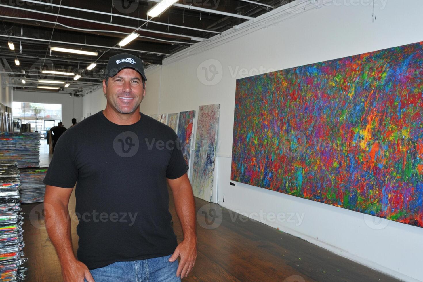 A man standing in front of a large painting photo