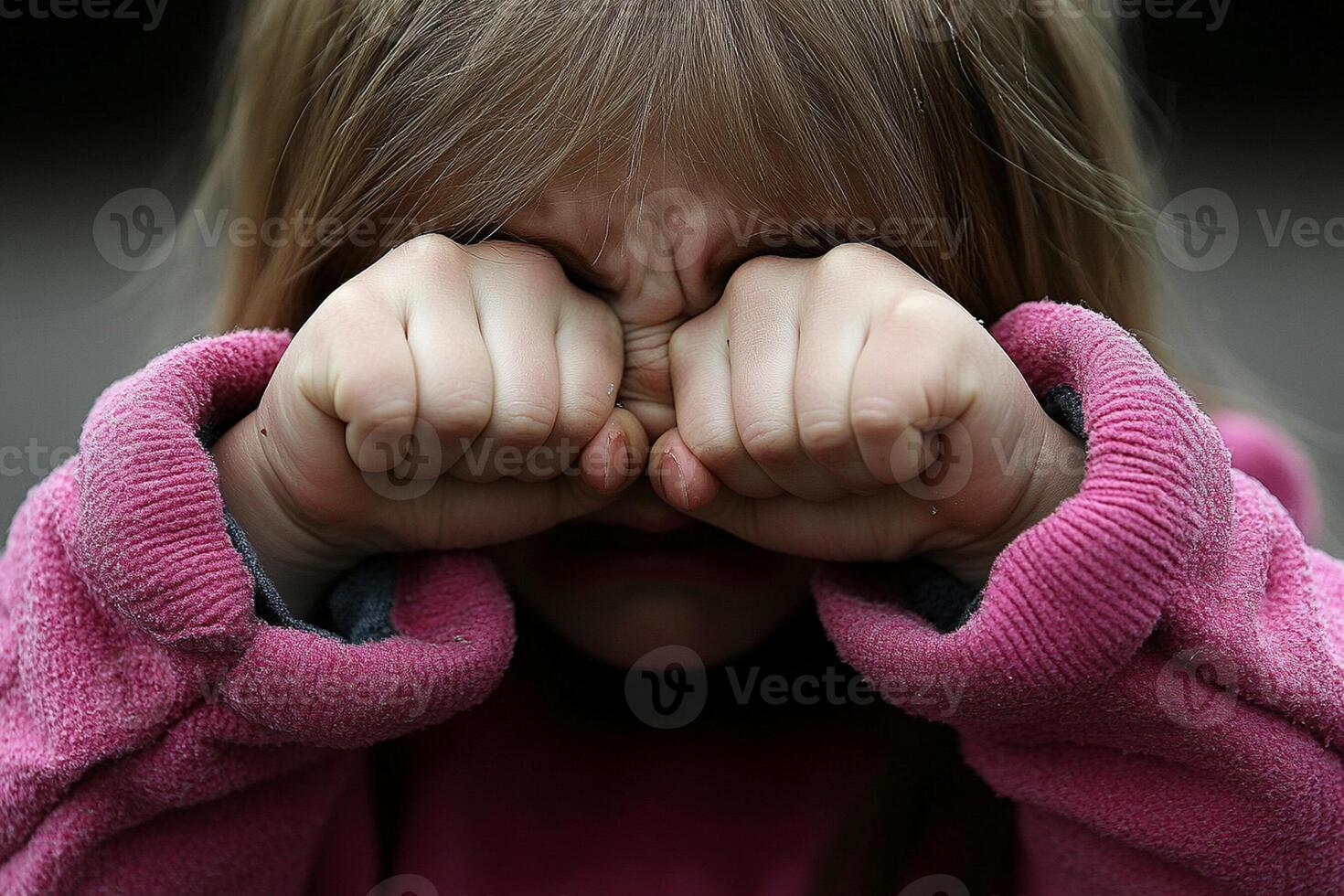 A little girl covering her face with her hands photo