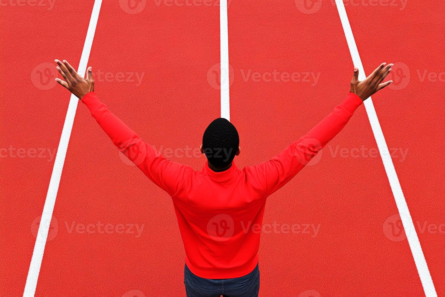 A man with arms raised on a red track photo