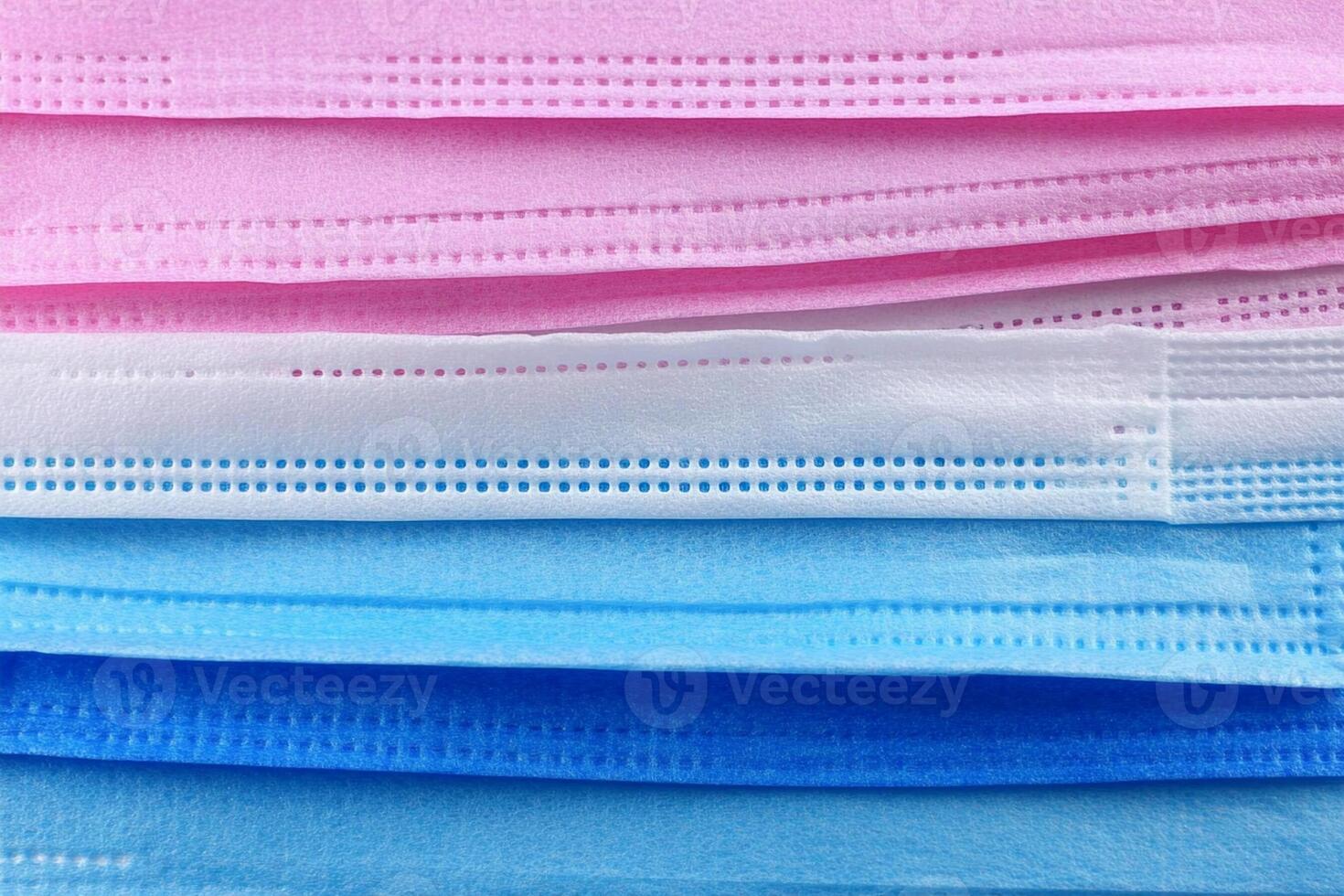 A stack of surgical masks in various colors photo